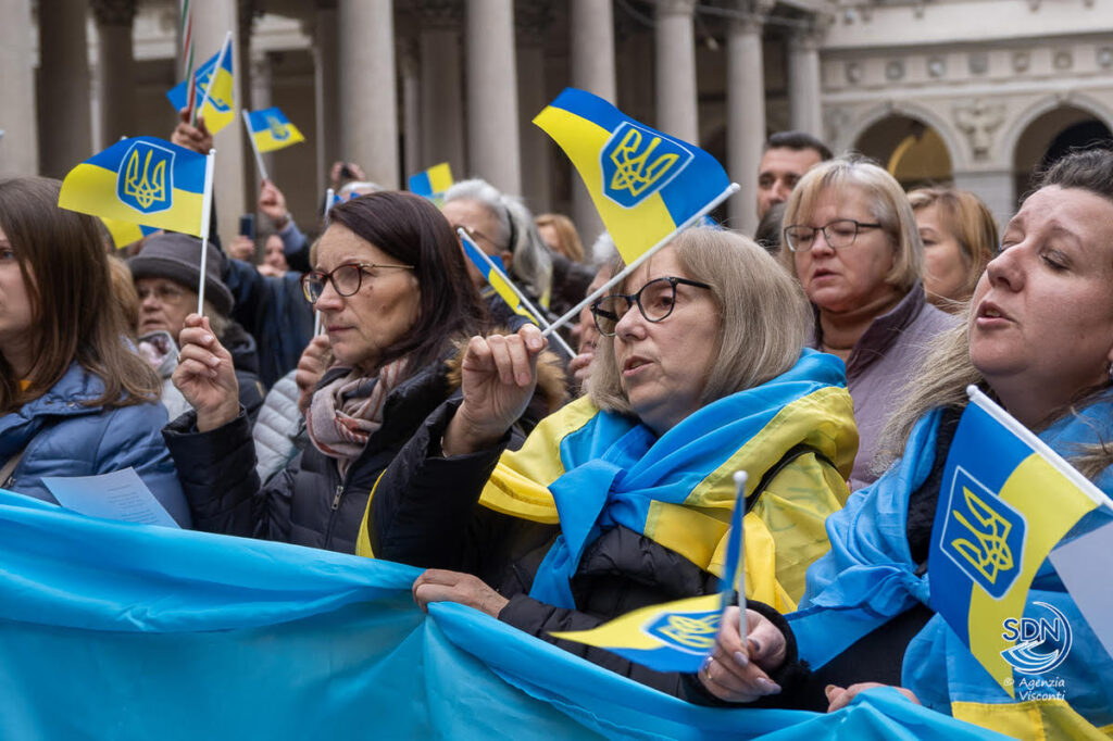 Uno scatto della manifestazione in piazza Duomo con i partecipanti ricoperti da bandiere ucraine